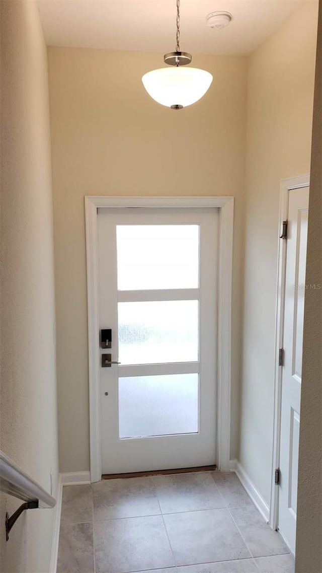 entryway with light tile patterned floors and baseboards