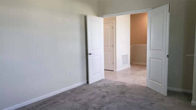 unfurnished bedroom with light carpet and baseboards