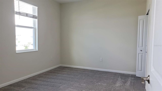 carpeted empty room featuring plenty of natural light and baseboards