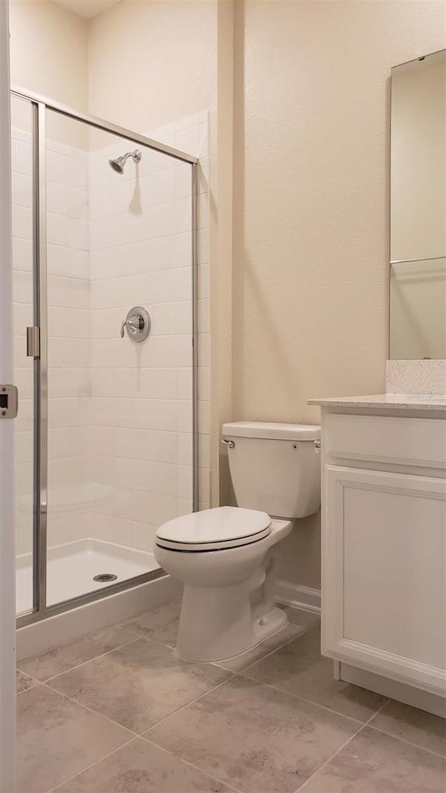 full bathroom featuring toilet, a shower stall, tile patterned floors, and vanity