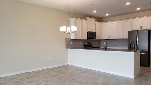 kitchen featuring black refrigerator with ice dispenser, a chandelier, electric range, dark countertops, and recessed lighting