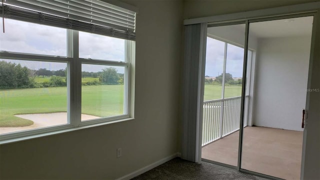 spare room with plenty of natural light and dark carpet