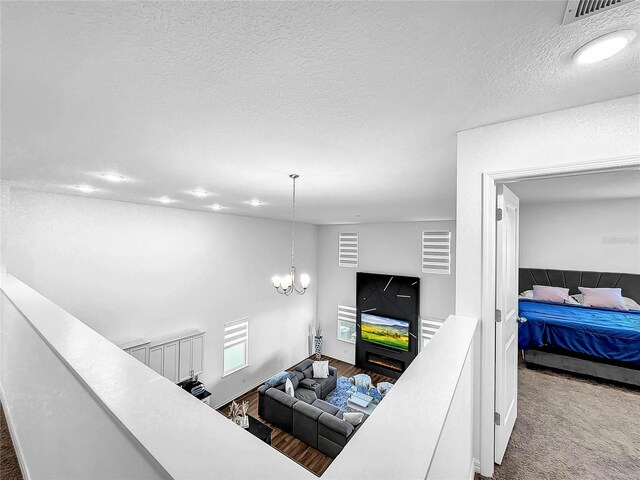living room featuring an inviting chandelier, visible vents, and a textured ceiling