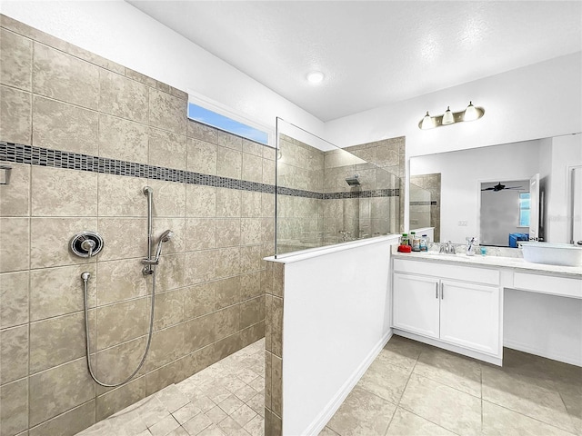 full bath with a walk in shower, vanity, tile patterned flooring, and a textured ceiling