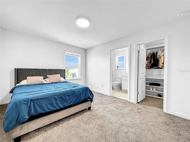 bedroom with a spacious closet, carpet flooring, baseboards, and multiple windows