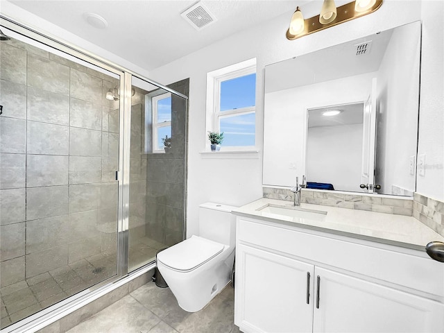bathroom featuring a shower stall, toilet, vanity, and tile patterned flooring
