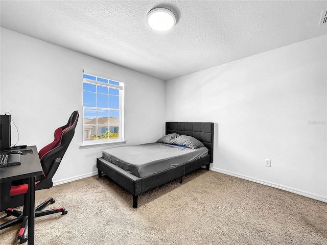 bedroom featuring carpet flooring, a textured ceiling, an office area, and baseboards