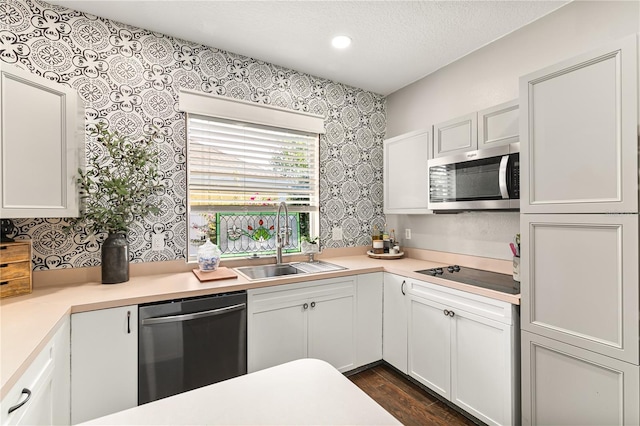 2623 Gables Dr, Eustis, FL 32726 - kitchen featuring stainless steel appliances, a sink, wallpapered walls, light countertops, and white cabinetry
