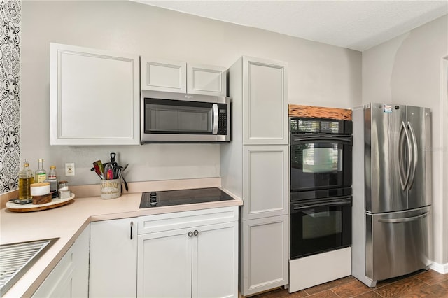 2623 Gables Dr, Eustis, FL 32726 - kitchen featuring black appliances, light countertops, a sink, and white cabinets
