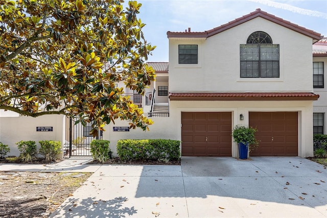 520 Via Verona Ln Unit 202, Altamonte Springs, FL 32714 - view of front facade featuring stucco siding, a tiled roof, concrete driveway, a garage, and a gate