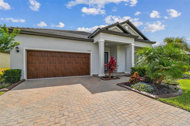 31840 Magna Gulf Loop, San Antonio, FL 33576 - view of front of property with stucco siding, decorative driveway, and a garage