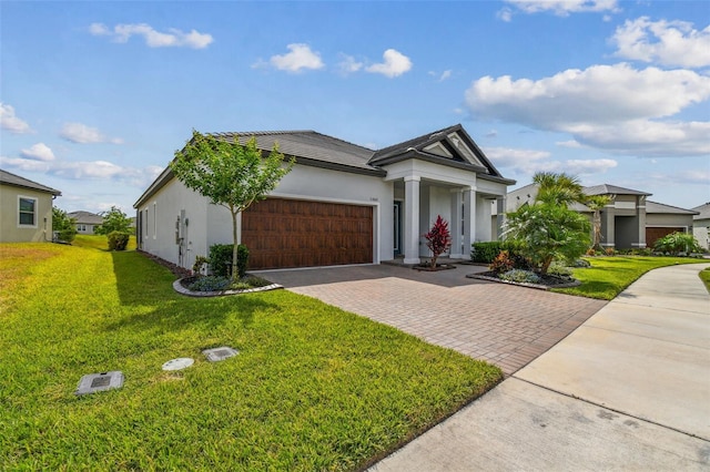 31840 Magna Gulf Loop, San Antonio, FL 33576 - view of front facade featuring an attached garage, decorative driveway, a front yard, and stucco siding