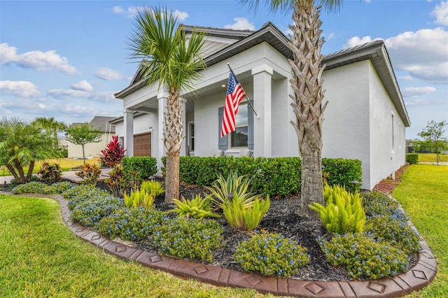 31840 Magna Gulf Loop, San Antonio, FL 33576 - view of home's exterior with stucco siding, an attached garage, a lawn, and covered porch