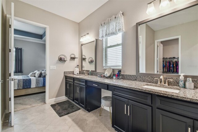 31840 Magna Gulf Loop, San Antonio, FL 33576 - bathroom with double vanity, ensuite bathroom, a walk in closet, tile patterned floors, and baseboards
