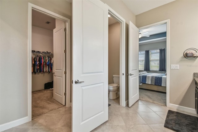 31840 Magna Gulf Loop, San Antonio, FL 33576 - ensuite bathroom featuring toilet, tile patterned floors, baseboards, and a ceiling fan
