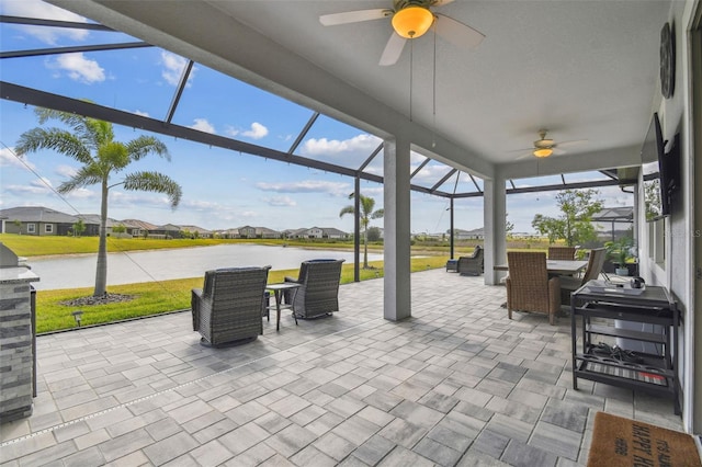31840 Magna Gulf Loop, San Antonio, FL 33576 - view of patio with a ceiling fan, outdoor dining area, a water view, a residential view, and glass enclosure