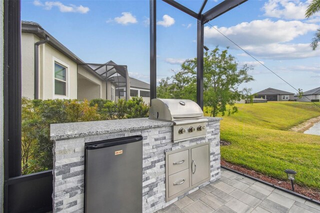 31840 Magna Gulf Loop, San Antonio, FL 33576 - view of patio featuring a grill, an outdoor kitchen, and a lanai