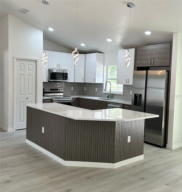 3082 SE 140th Ln, Summerfield, FL 34491 - kitchen featuring light countertops, tasteful backsplash, appliances with stainless steel finishes, and light wood-style flooring