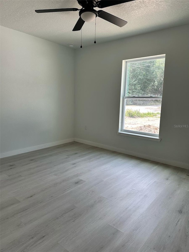 3082 SE 140th Ln, Summerfield, FL 34491 - unfurnished room featuring a textured ceiling, baseboards, a ceiling fan, and wood finished floors