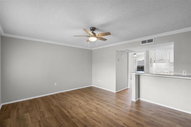 unfurnished living room with a ceiling fan, wood finished floors, ornamental molding, baseboards, and a textured ceiling