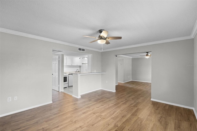 unfurnished living room featuring ceiling fan, light wood-style flooring, baseboards, crown molding, and a sink