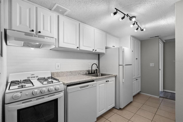 kitchen featuring white appliances, under cabinet range hood, a textured ceiling, a sink, and white cabinetry