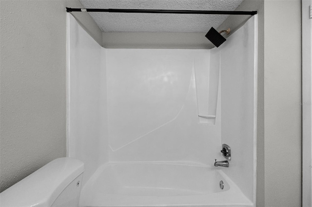 bathroom with shower / tub combination, toilet, a textured ceiling, and a textured wall