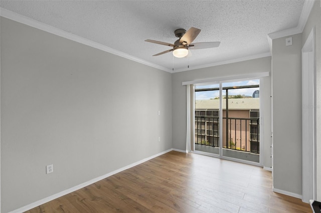 unfurnished room featuring a ceiling fan, wood finished floors, a textured ceiling, ornamental molding, and baseboards