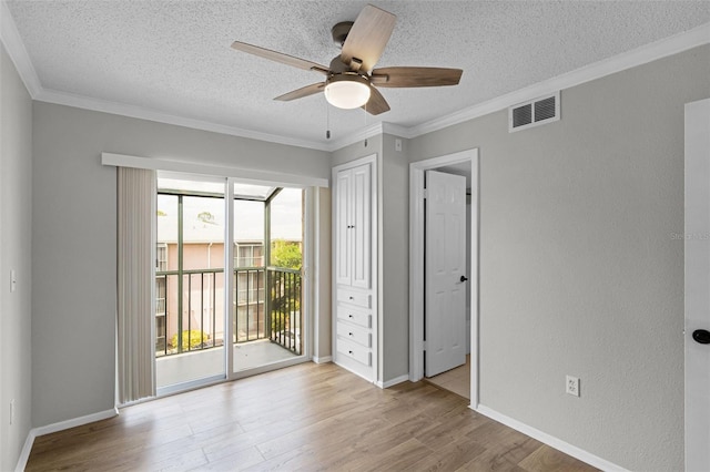 unfurnished bedroom with access to outside, a textured ceiling, light wood-type flooring, crown molding, and baseboards