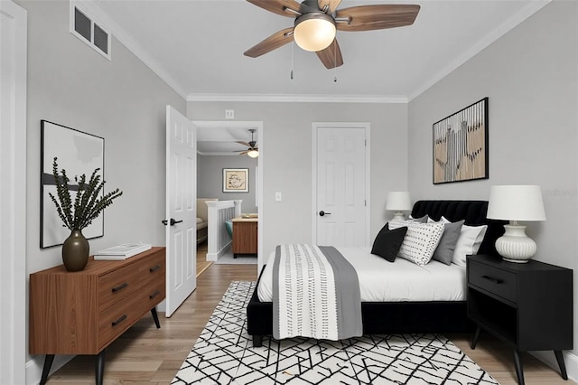 bedroom featuring light wood-style floors, ornamental molding, and a ceiling fan