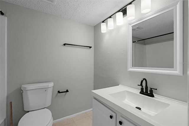 bathroom featuring a textured ceiling, tile patterned flooring, toilet, vanity, and baseboards