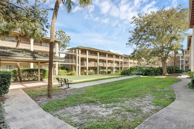surrounding community featuring a game area and a lawn