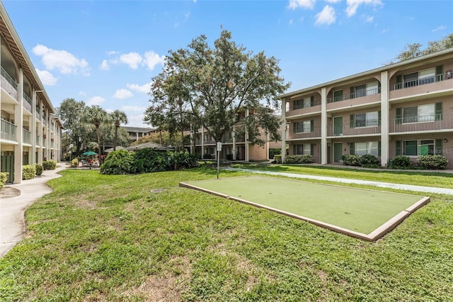 view of community featuring a lawn and a putting green