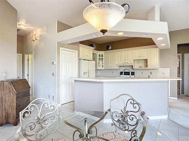 502 Canopy Ln, Lady Lake, FL 32159 - kitchen featuring white fridge with ice dispenser, light countertops, a center island with sink, light tile patterned flooring, and under cabinet range hood