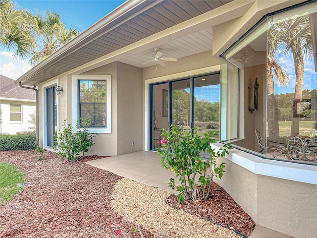 502 Canopy Ln, Lady Lake, FL 32159 - view of exterior entry featuring stucco siding, a ceiling fan, and a patio area