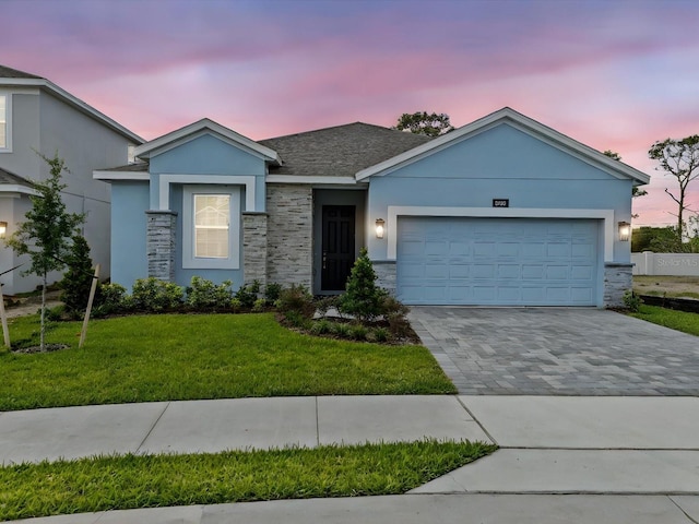 8018 Colby Cir, Orlando, FL 32817 - ranch-style home with a front yard, decorative driveway, an attached garage, stucco siding, and stone siding