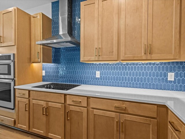 8018 Colby Cir, Orlando, FL 32817 - kitchen with wall chimney exhaust hood, black electric cooktop, light countertops, tasteful backsplash, and stainless steel double oven