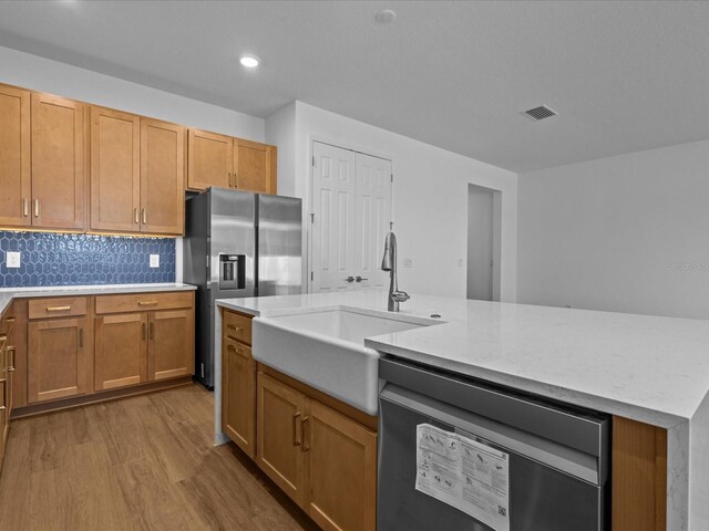 8018 Colby Cir, Orlando, FL 32817 - kitchen with dishwashing machine, stainless steel refrigerator with ice dispenser, a sink, light wood-style flooring, and backsplash