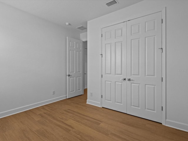 8018 Colby Cir, Orlando, FL 32817 - unfurnished bedroom with light wood-style floors, baseboards, and a closet