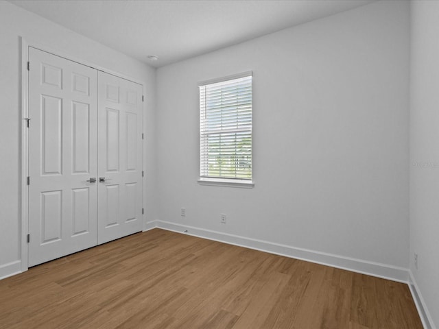 8018 Colby Cir, Orlando, FL 32817 - unfurnished bedroom with light wood-type flooring, baseboards, and a closet