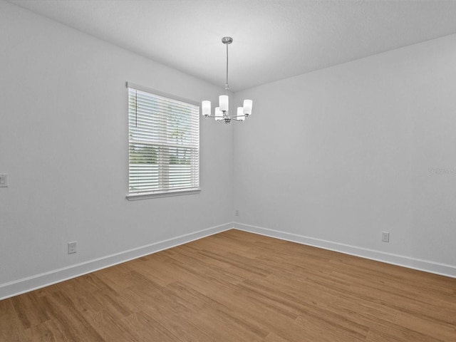8018 Colby Cir, Orlando, FL 32817 - empty room featuring a chandelier, baseboards, and light wood-type flooring