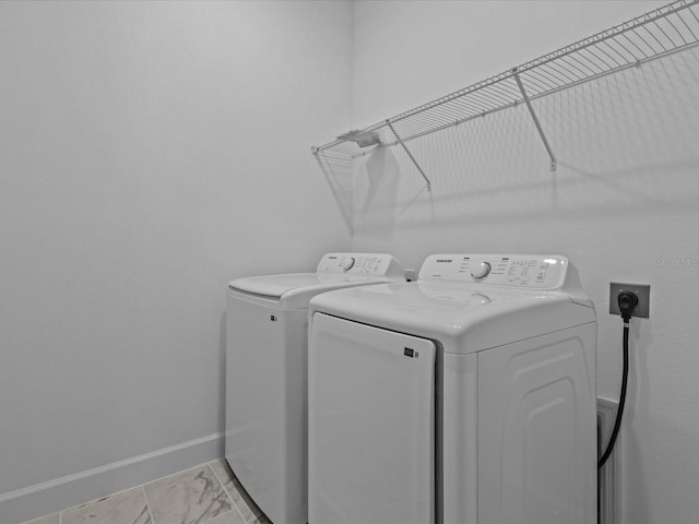 8018 Colby Cir, Orlando, FL 32817 - washroom with washing machine and dryer, baseboards, and light marble finish flooring