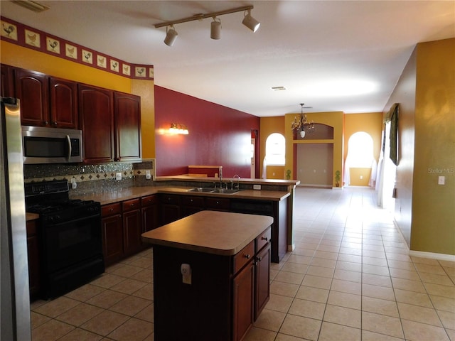 7045 Branch Ct, Saint Cloud, FL 34771 - kitchen with stainless steel appliances, light tile patterned floors, a sink, tasteful backsplash, and a peninsula