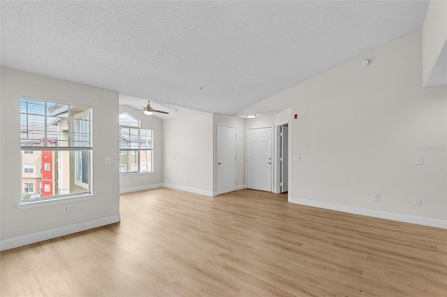 2213 Grand Cayman Ct Unit 1138, Kissimmee, FL 34741 - unfurnished room with light wood-style flooring, ceiling fan, a textured ceiling, vaulted ceiling, and baseboards