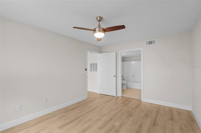 2213 Grand Cayman Ct Unit 1138, Kissimmee, FL 34741 - unfurnished bedroom with light wood-style floors, baseboards, a textured ceiling, ensuite bath, and a ceiling fan