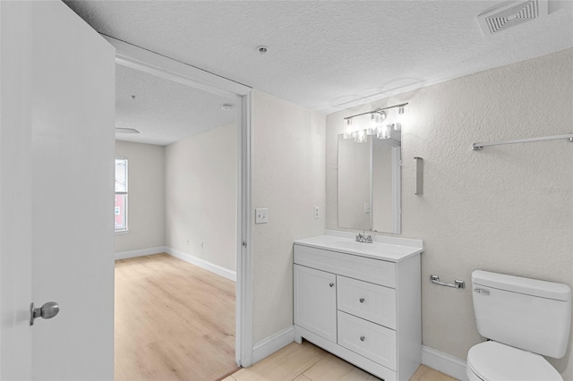 2213 Grand Cayman Ct Unit 1138, Kissimmee, FL 34741 - bathroom featuring toilet, a textured ceiling, wood finished floors, vanity, and baseboards