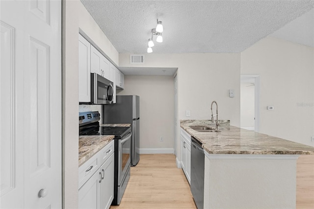 2213 Grand Cayman Ct Unit 1138, Kissimmee, FL 34741 - kitchen with stainless steel appliances, a sink, a peninsula, light wood finished floors, and white cabinets