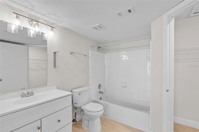 2213 Grand Cayman Ct Unit 1138, Kissimmee, FL 34741 - full bath featuring toilet, a textured ceiling, vanity, wood finished floors, and a spacious closet