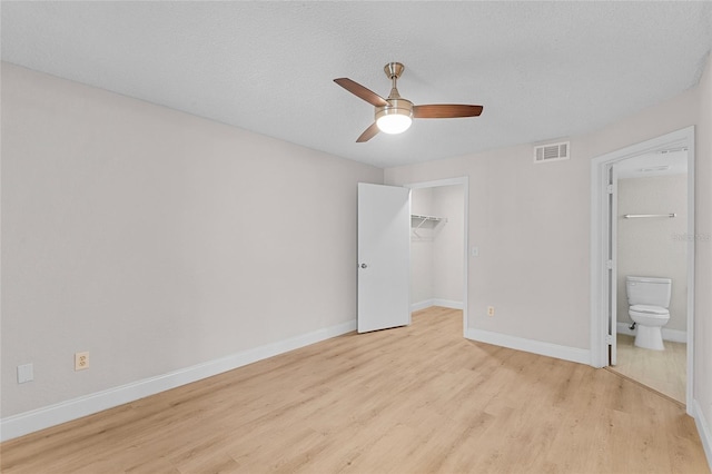 2213 Grand Cayman Ct Unit 1138, Kissimmee, FL 34741 - unfurnished bedroom with light wood-type flooring, baseboards, a walk in closet, ceiling fan, and a closet