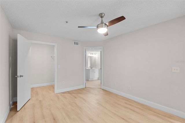 2213 Grand Cayman Ct Unit 1138, Kissimmee, FL 34741 - unfurnished bedroom with a spacious closet, light wood-style flooring, a textured ceiling, baseboards, and a closet